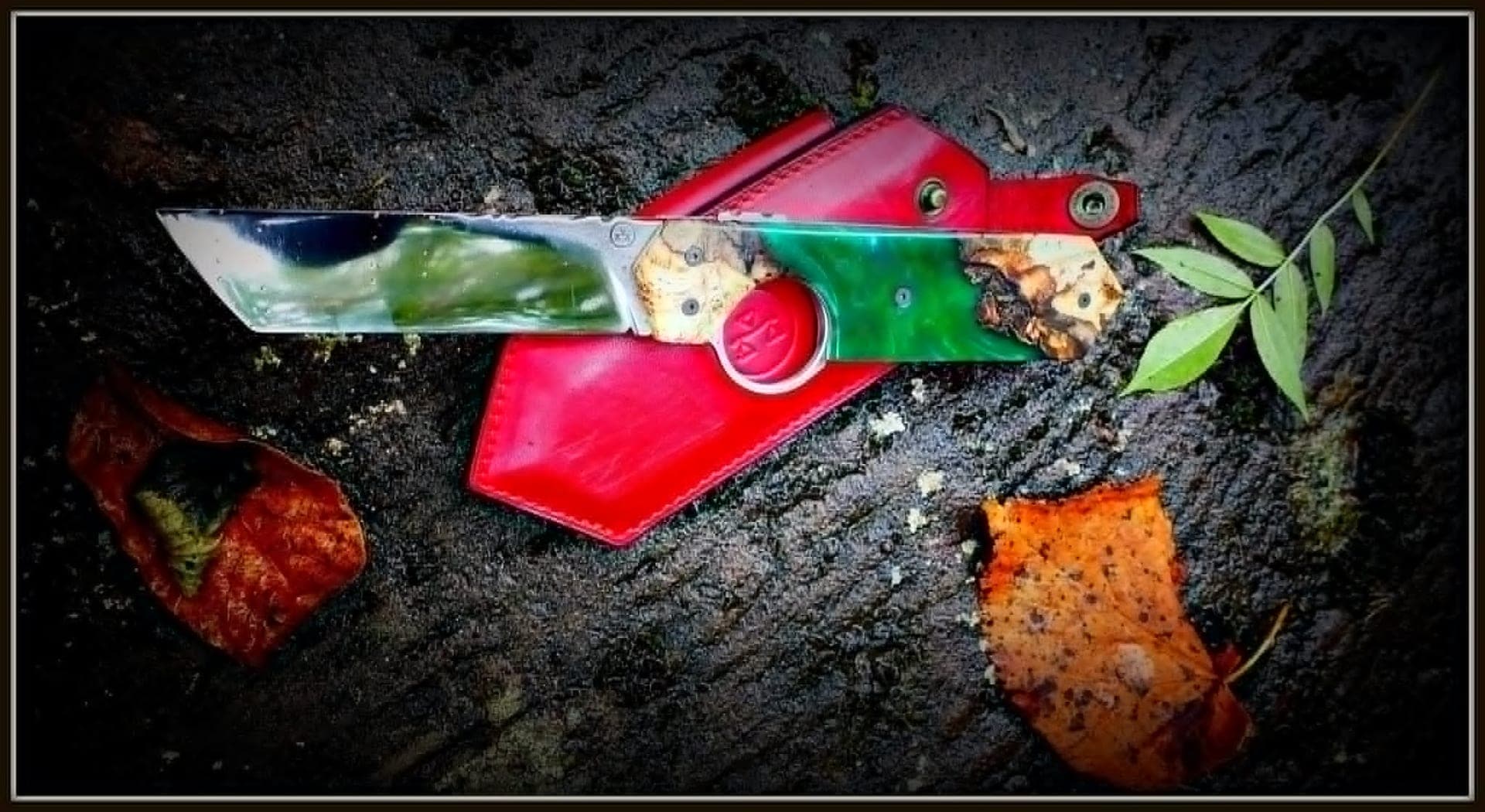 Le Résiliant Tanto open beside its red leather sheath, resting on a tree stump in the forest.