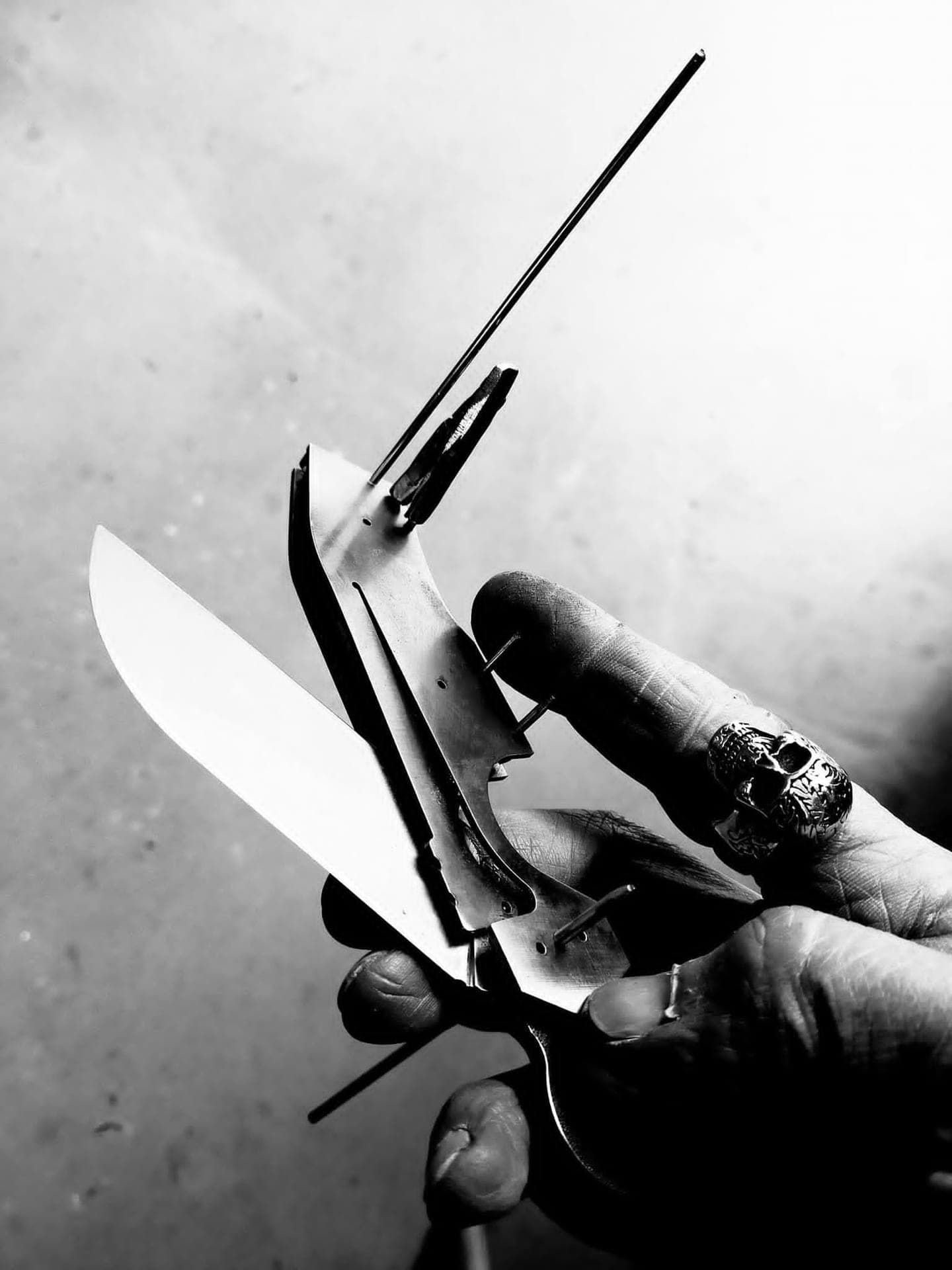 Knife being assembled in hand, liners and pins exposed